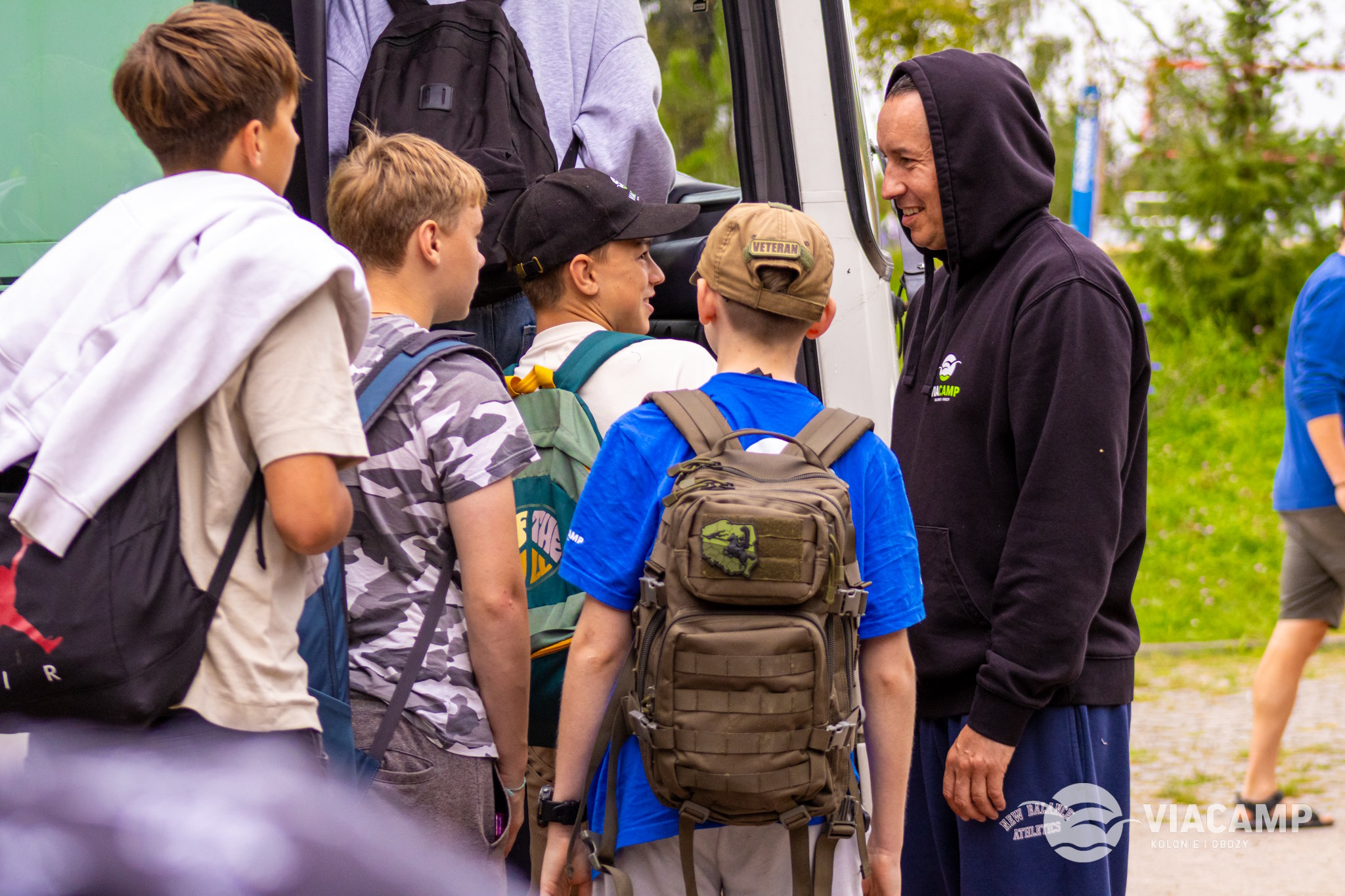 Dzieci z plecakami wsiadają do autobusu